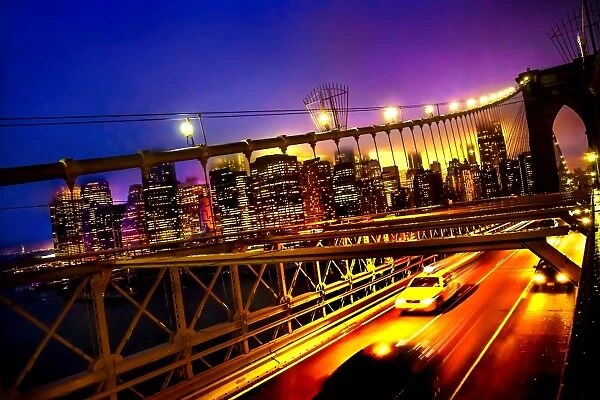 A tilted view of a yellow cab speeding along the Brooklyn Bridge at dusk