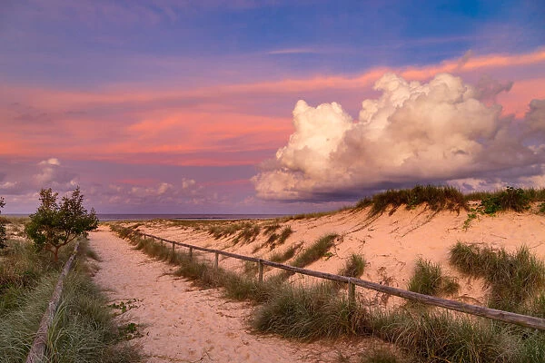 Vibrant storm clouds at sunset over a sandy beach