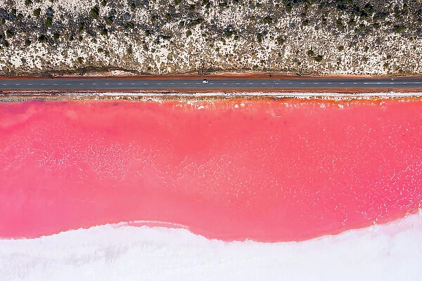 Top down view of car on a road near pink salt lake, Australia