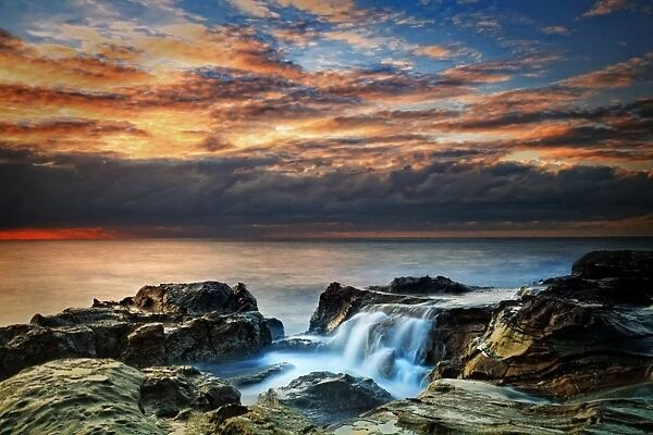 Water flowing over rocks at sunrise