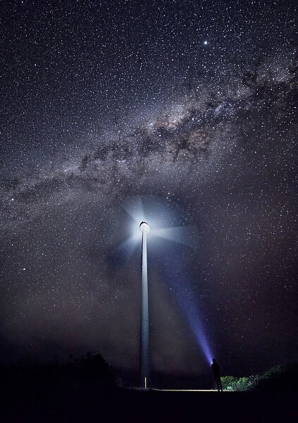 Wind turbine spinning at night with the Milky Way in the sky