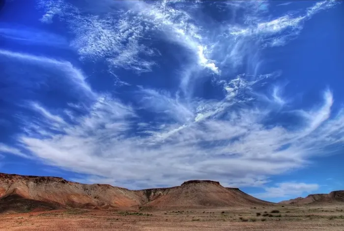 Framed Print : Wispy clouds over desert