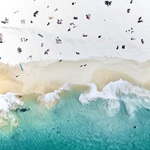 An aerial beach shot of people sitting on the beach