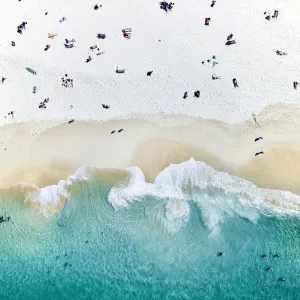 Une vue aérienne d'une plage avec des gens assis sur la plage.