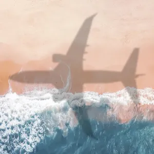 Vue aérienne d'une ombre d'avion sur une plage de sable.