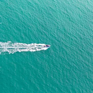 Aerial view of fast travelling boat on an island