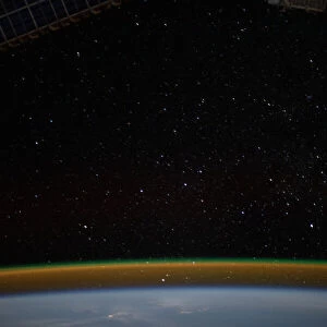 Airglow blankets the Earths horizon beneath a starry sky