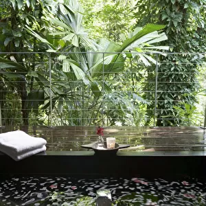 Bath on wooden terrace overlooking rainforest