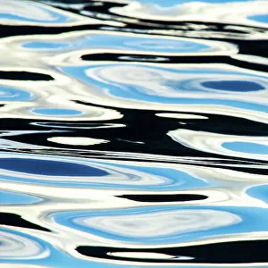 Blue, black and white colours reflected in the sea. Calm ocean water