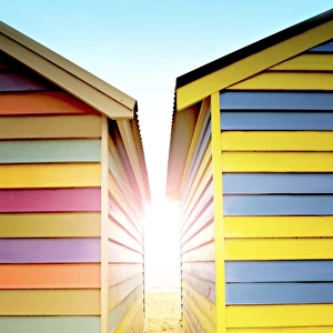 Bright sunlight between beach huts