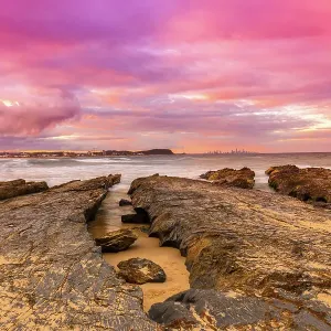 Bright and vibrant colored Sunset over the ocean with rock formations Bright and vibrant colored Sunset over the ocean with rock formations