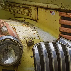 Close-up of the headlight and grill of a rusty old car