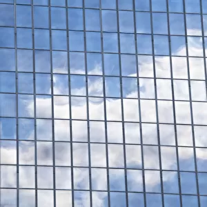 Clouds and sky reflected in mirrored windows of an office building