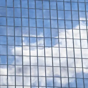 Clouds and sky reflected in mirrored windows of an office building