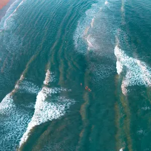 crystal clear waters with swimmers as seen from above
