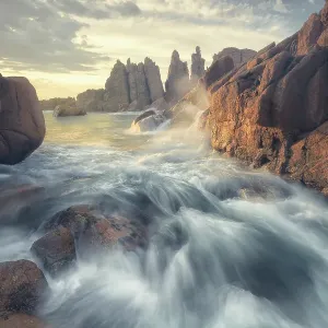 Dramatic view of crashing waves, ocean, rocks and rocky coastline at sunset in Victoria, Australia
