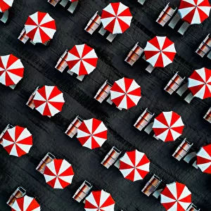 Drone image directly above beach umbrellas, Massa, Italy