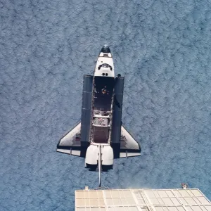 Elevated view of the space shuttle orbiting above earth with its cargo bay open Elevated view of the space shuttle orbiting above earth with its cargo bay open