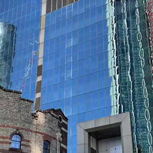 Glass office block and old brick historic building facade, Sydney, Australia