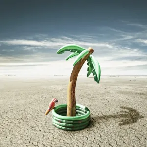 Little piece of paradise Print: Blow up palm tree in desert landscape