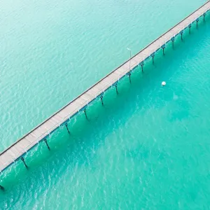 Long jetty out into the clear aqua ocean water