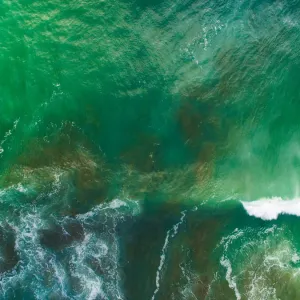 Top looking down at sea waves splashing at Muriwai Beach, Auckland