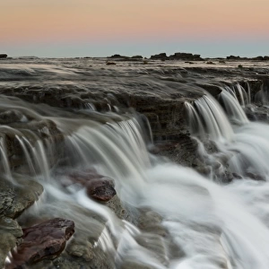 Moon rising over seascape waterfall