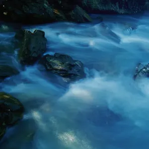 New South Wales, Australia. Blue pastel water breaks over rocks at Bittangabee Bay New South Wales, Australia. Blue pastel water breaks over rocks at Bittangabee Bay