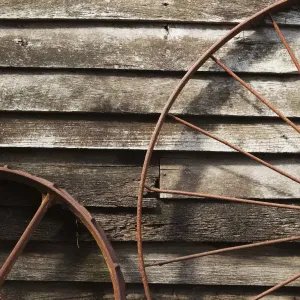 Old Wagon Wheels Against A Wooden Wall Old Wagon Wheels Against A Wooden Wall