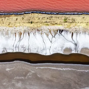 Overhead photo showing the shoreline of a vibrant coloured salt lake, Queensland, Australia