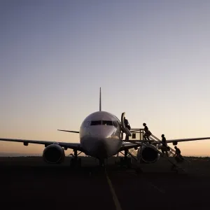 Print of People boarding an airplane at dusk in Port Hedland