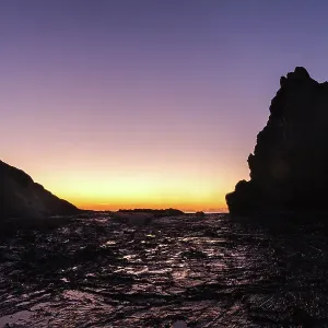 Pre dawn light silhouetting the rocks at Currumbin at the Gold Coast. The first light is reflecting on the water on the foreground rocks Pre dawn light silhouetting the rocks at Currumbin at the Gold Coast. The first light is reflecting on the water on the foreground rocks