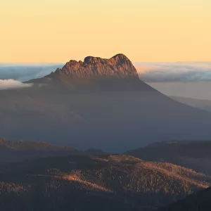 Precipitous Bluff rising above Southwest Tasmania at sunset viewed from Mt Geeves