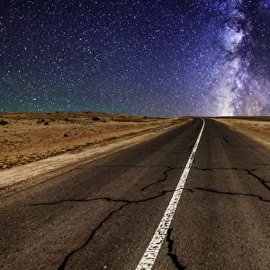 Road in the desert at night with the Milky Way