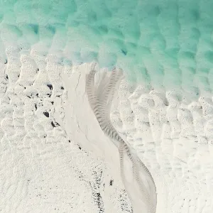 Stream of water flowing across a sandbar into Willie Creek estuary, Western Australia, Australia Stream of water flowing across a sandbar into Willie Creek estuary, Western Australia, Australia