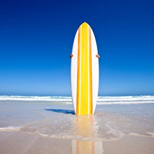 Striped retro surf board on a beach. Australia