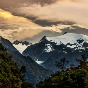 The sun setting over the Franz Josef glacier located on the south island of New Zealand The sun setting over the Franz Josef glacier located on the south island of New Zealand