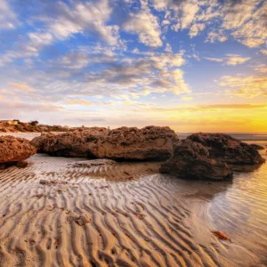 Sunset with Big Rocks and Sand Patterns at the Beach