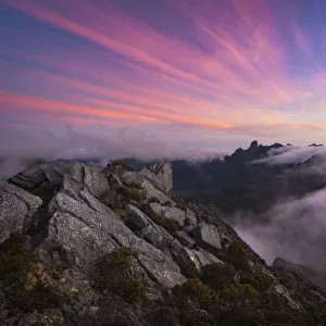 Sunset and fog flow over Federation Peak and the Eastern Arthur Range from the summit of