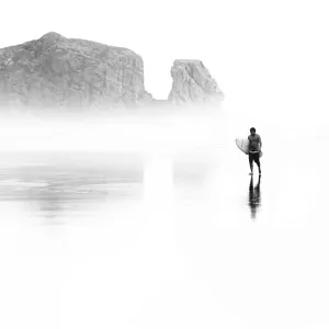 Surfer at Bethells Beach (Te Henga) on Aucklands west coast