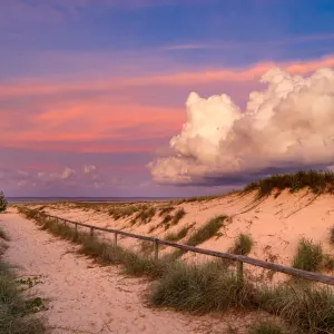 Vibrant storm clouds at sunset over a sandy beach