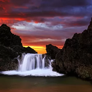 Water cascading over rock at sunrise