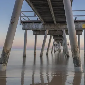 Water flowing under a jetty at Sunrise in Hervey Bay Water flowing under a jetty at Sunrise in Hervey Bay