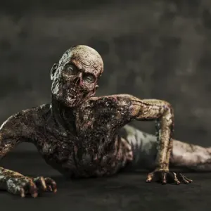 Uomo zombi che si trascina a terra.
