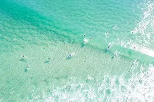 Aerial point of View crystal clear ocean waters with people surfing
