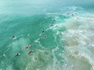 Images Dated 20th July 2023: Aerial shot showing surfers paddling out to the waves on the Coral Sea