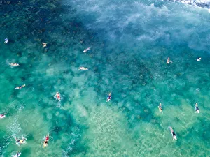 Aerial View over blue and green clear ocean waters with surfers Aerial View over blue and green clear ocean waters with surfers
