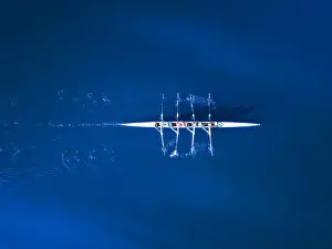 Aerial view of a rowing boat surrounded by classic blue water