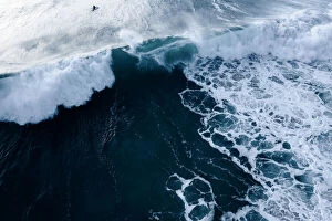 Ocean Wave Aerials Collection: Aerial Viewpoint of a bright sunrise and deep blue ocean waters with people surfing