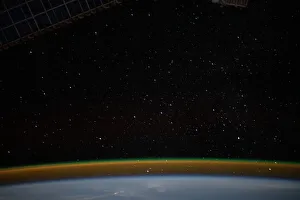 Airglow blankets the Earths horizon beneath a starry sky